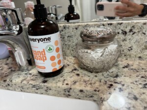 photo of sink with handsoap and glass container next to it