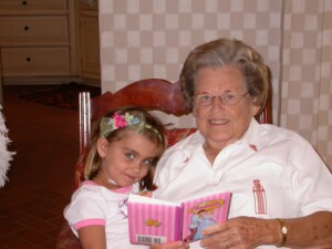 Photo of grandma and granddaughter reading in a rocking chair