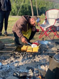Matt preparing french toast over fire at retreat
